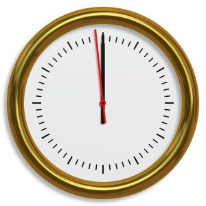 金色の縁の丸時計11時59分を指す