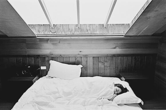 布団で寝る女性の白黒写真